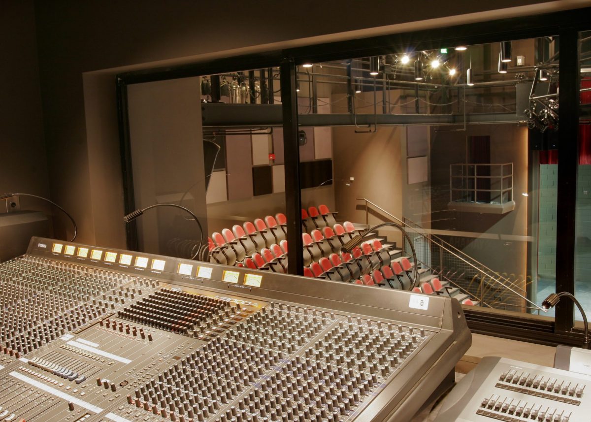 Aktor w kabinie dubbingowej obok hologramu głosu modyfikowanego w czasie rzeczywistym AI