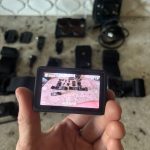 Różne modele kamer akcji 4K ustawione na stole z uchwytami i bateriami