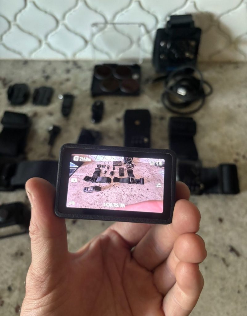 Różne modele kamer akcji 4K ustawione na stole z uchwytami i bateriami