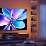 Elementor #1205 Nowoczesny salon z ogromnym telewizorem LED 85 cali na ścianie, wygodna sofa i stolik kawowy