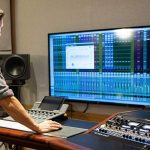 Reżyser na planie filmowym obserwuje ekran z falami dźwiękowymi generowanymi przez AI