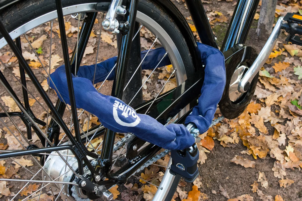 Próba kradzieży roweru słabym zabezpieczeniem z łańcuchem Złodziej z nożycami do bolców próbujący przeciąć łańcuch na zaparkowanym rowerze