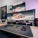 Szeroki zakrzywiony monitor ultrawide na biurku z otwartymi oknami dokumentów i narzędzi biurowych