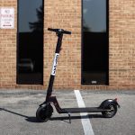 inteligentny skuter elektryczny poruszający się po miejskiej ulicy z widoczną baterią